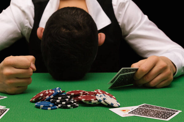 Опустошённый игрок проигрывает кучу денег, играя в покер в казино, увлекаясь азартными играми. Развод, потеря, разорение, долг, концепция ludopata.