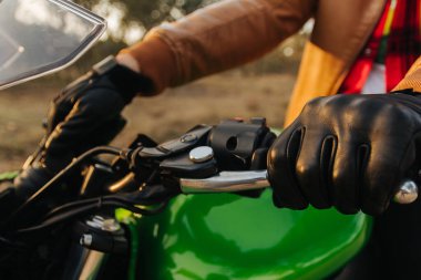 Bir motosikletlinin elleri yolda. Boş bir yolda motosiklet sürerken eğleniyor.