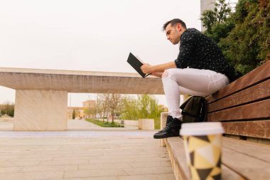 Latin ve İspanyol özellikleri olan genç bir öğrenci, açık havada kitap okuyor. yaşam tarzı konsepti