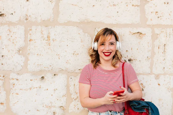 Mujer Hispana Riendo Escuchando Música Con Auriculares Mientras Usa Teléfono —  Fotos de Stock
