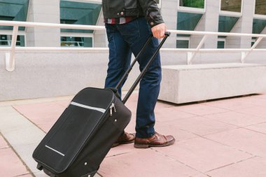 İş gezisinde bavuluyla gezen bir adamın bacakları..