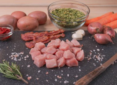 Bezelye çorbası için malzemeler ahşap bir masanın üzerinde ve etrafında uzanır..