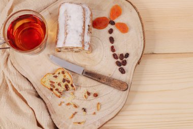 Çayı, bıçağı ve kurumuş meyveli Noel keki soldaki tahtada çiçek şeklinde ve sağda yazı için bir yer var..