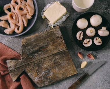 Mantar çorbası ve gri taştan arka planda boş kesim tahtası için malzemeler, üst görünüm yakın plan.