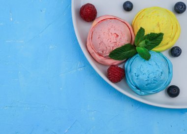 Böğürtlenli dondurma ve sağ arka planda bir tabakta nane şekeri ve sol üstte de yakın çekim için bir metin yeri var..