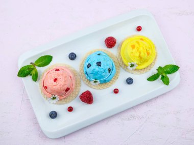 Waffle, nane ve taze böğürtlenli dondurma. Pembe arka plan görüntüsünde çapraz dizilmiş. Yakın plan..