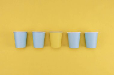 Sarı arka planda beş eko kağıt bardak var, en üstteki yakın plan..