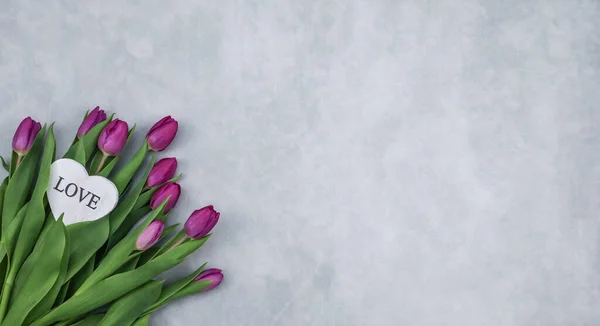 Bukiet Purpurowych Tulipanów Białym Sercem Leży Lewej Stronie Szarym Betonowym — Zdjęcie stockowe