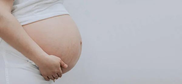 Kobieta Ciąży Dotyka Brzucha Stoi Lewej Stronie Szarym Tle Miejscem — Zdjęcie stockowe
