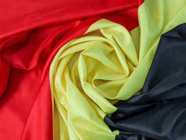 Belçika bayrağının dokusu ortadan bükülmüş, üst taraf yakın çekim.