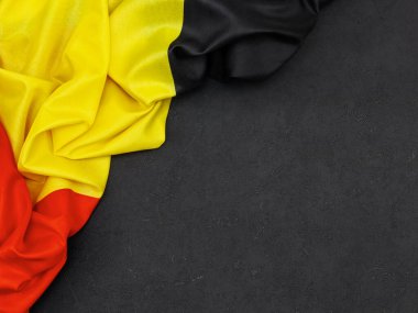 Belçika bayrağı siyah bir arkaplanda sağda metin için boşluk, en üstte ise yakın plan.