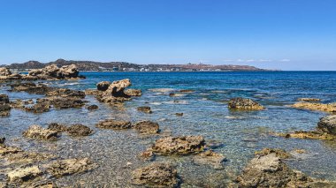 Dağ manzaralı, kayalık bir sahil..