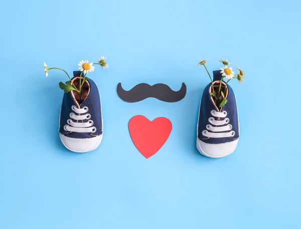 Pair Baby Sneakers Daisies Paper Lips Mustache Lie Blue Background — Stock Photo, Image