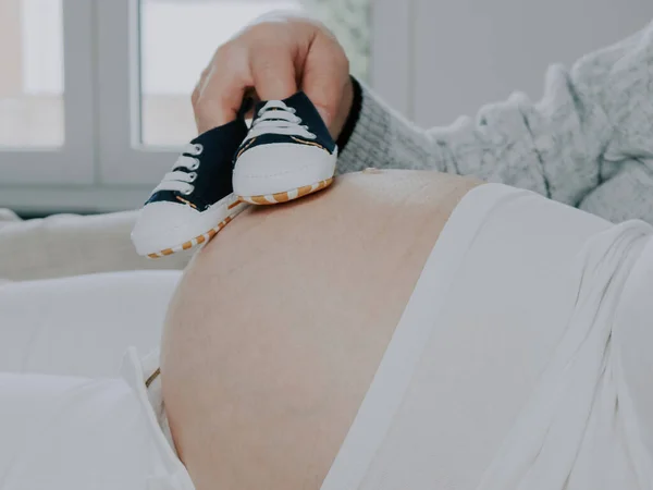 Otec Drží Dětské Boty Břiše Těhotné Matky Boční Pohled Zblízka — Stock fotografie