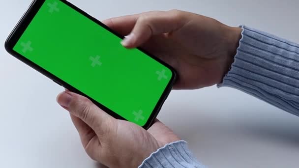 Mani femminili e un telefono con schermo verde. — Video Stock
