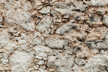 Düzensiz şekillendirilmiş ve boyutlandırılmış gri ve bej tonlarında orta boy taşlardan oluşan, atmosferik kayalık bir dokunun güzel bir görüntüsü. Kavram: Doğal altyapı ve dokular.