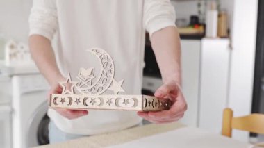 Masada duran genç, tanınmayan bir adam, oyulmuş ahşap tepsiyi bitirdikten sonra, yakın çekim, yavaş çekimde gösterir. Konsept: tepsi montajı, Ramazan Kareem, Bayram Mübarek.