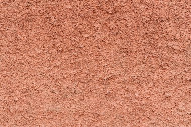 Çitin kenarından pembe bir palto ve çimento duvarının güzel yakın plan görüntüsü. İnşaat arka planlarını ve dokularını kavramsallaştır.