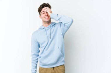 Beyaz arka planda izole olmuş genç beyaz bir adam gülüyor, kaygısız, doğal bir duygu..