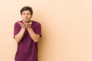 Genç, havalı adam, dudaklarını katlıyor, avuç içlerine uzanıyor..