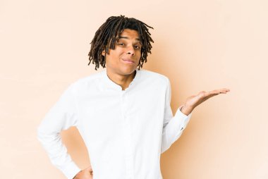 Genç Afrikalı Amerikalı Rasta adam sorgulama jesti için omuz silkiyor ve şüphe ediyor..