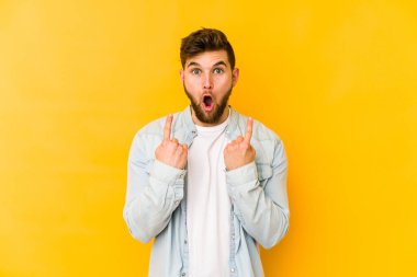 Sarı arka planda izole edilmiş beyaz bir adam ağzı açık bir şekilde üst tarafı işaret ediyor..