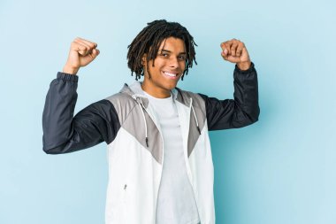 Genç Afro-Amerikan sporcusu kadınsı gücün sembolü olan kollarıyla güç gösterisi yapıyor.