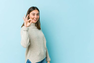 Genç, beyaz, neşeli ve kendinden emin bir kadın iyi bir jest yapıyor..