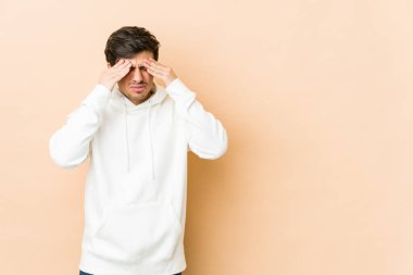 Genç havalı adamın başı ağrıyor, yüzüne dokunuyor..