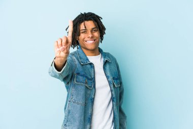 Kot ceket giyen genç siyahi bir adam bir numarayı parmağıyla gösteriyor..