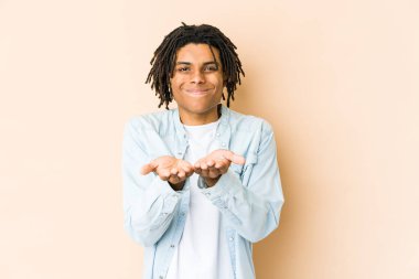 Genç Afrikalı Amerikalı Rasta adam elinde avuç içi bir şeyle kameraya teklif ediyor..