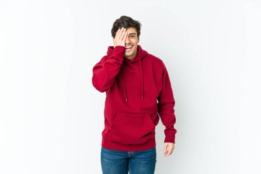 Genç havalı adam yüzünün yarısını avuç içiyle kaplayarak eğleniyor..