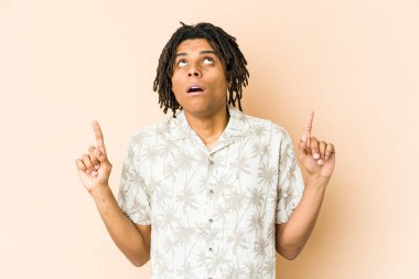 Genç Afrikalı Amerikalı Rasta adam ağzı açık bir şekilde üst tarafı işaret ediyor..
