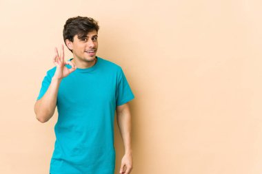 Genç, havalı bir adam göz kırptı ve elleriyle iyi bir jest yaptı..