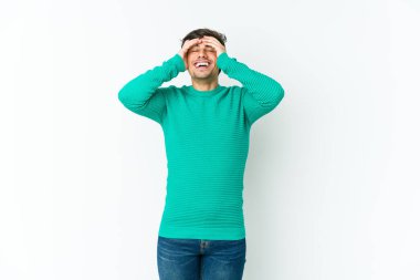 Genç havalı adam ellerini başının üstünde tutarak neşeyle güler. Mutluluk kavramı.