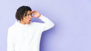 Genç Afro-Amerikan Rasta adam uzaklara bakıyor ve elini alnına koyuyor..