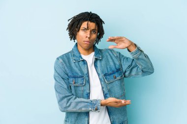 Kot ceket giyen genç siyah bir adam iki eliyle bir şey tutuyor, ürün sunumu..