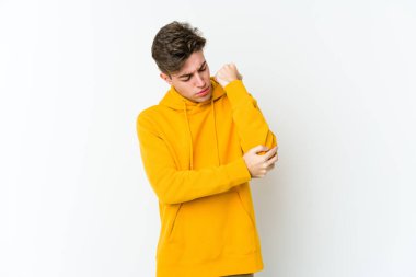 Beyaz arka planda izole edilmiş beyaz tenli genç bir adam kötü bir hareketin ardından acı çekiyor..