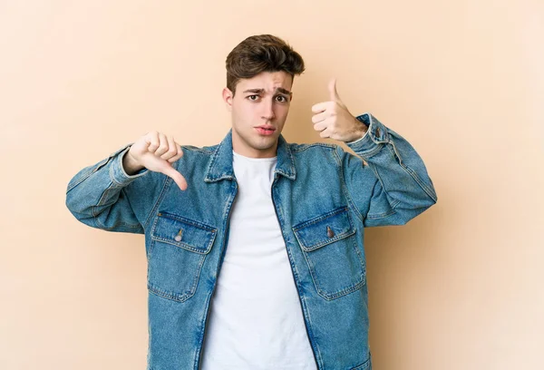 Young Caucasian Man Isolated Beige Background Showing Thumbs Thumbs Difficult — Stock Photo, Image