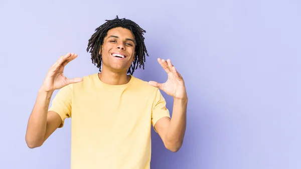 Joven Afroamericano Rasta Hombre Celebración Algo Con Palmas Ofreciendo Cámara —  Fotos de Stock