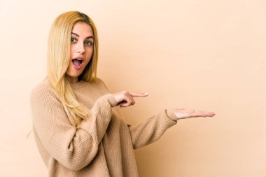 Sarışın, beyaz bir kadın, elinde bir fotokopi odası tutarken heyecanlanıyor..