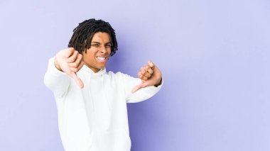 Genç Afrikalı Amerikalı Rasta adam baş parmağını aşağı gösteriyor ve hoşlanmadığını ifade ediyor..