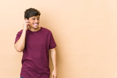 Elleriyle kulaklarını kapatan genç havalı adam..