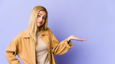 Sarışın, beyaz bir kadın şüphe ediyor ve soru sorarken omuz silkiyor..