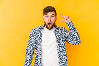 Sarı arka planda izole edilmiş genç beyaz bir adam harika bir fikri, yaratıcılık kavramı var..