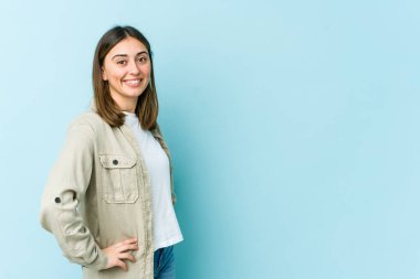 Genç beyaz kadın kendine güveniyor, ellerini kalçasında tutuyor..