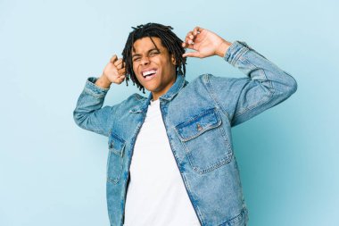 Kot ceket giyen, kollarını uzatan, rahat duruşu olan genç bir zenci..