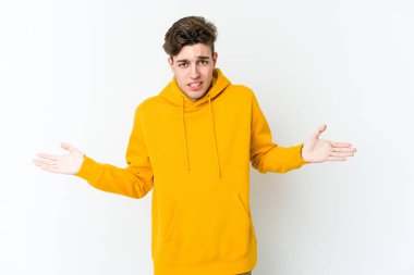 Beyaz arka planda izole edilmiş genç beyaz bir adam. Kafası karışmış ve omuz silkiyor. Kopya alanını tutmak için..