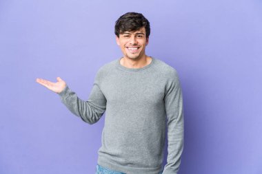 Havalı bir genç avucunun içinde fotokopi alanı gösteriyor ve başka bir eli belinde tutuyor..