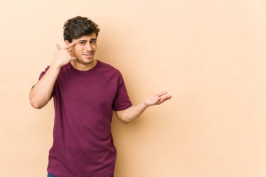 Genç havalı adam işaret parmağıyla hayal kırıklığı jesti yapıyor..